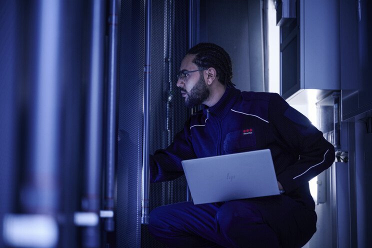 Securitas security professional using a laptop in a data center.